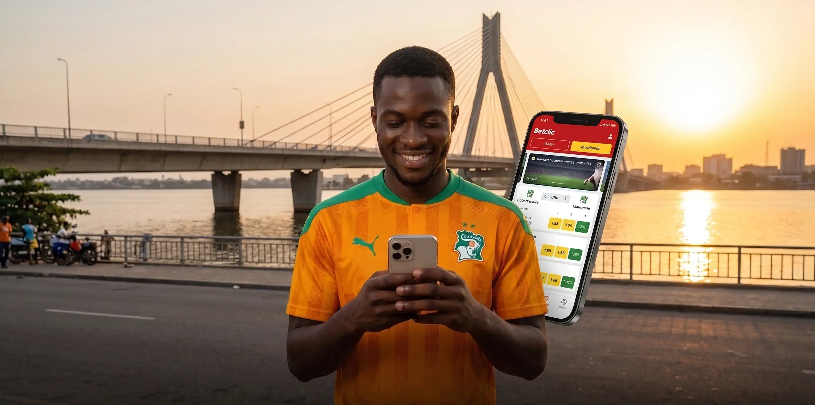 Parieur ivoirien utilisant Betclic sur smartphone en bord de lagune à Abidjan